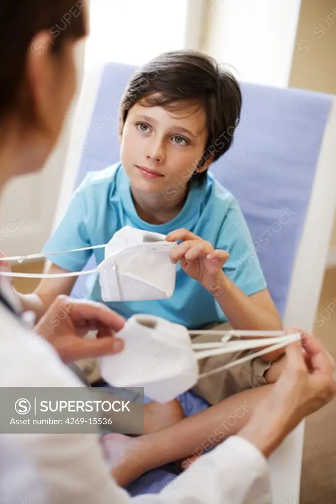 The French Health Minister recommends to wear a protection mask in case of viral respiratory diseases (cold, bronchitis and flu). A doctor explains a 9 years old child how to use the mask.