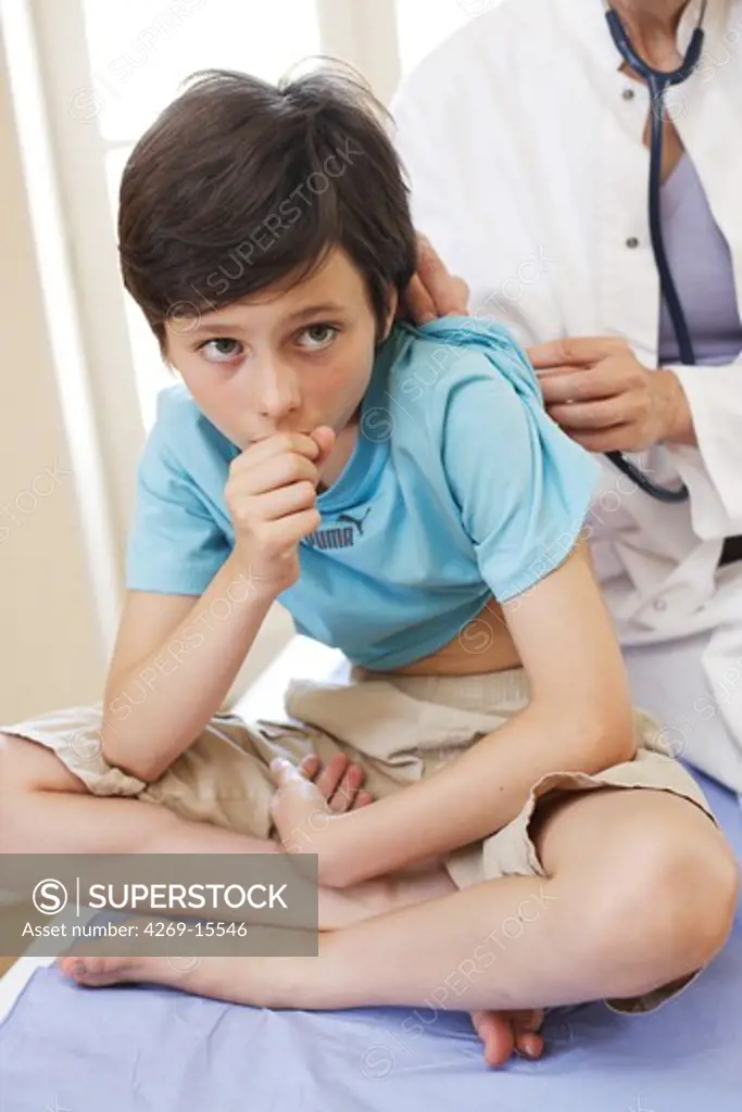 Doctor examining a 9 years old boy with a stethoscope.