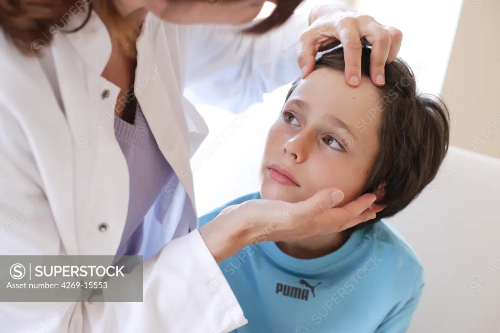 Doctor examining the face of 9 years old child.