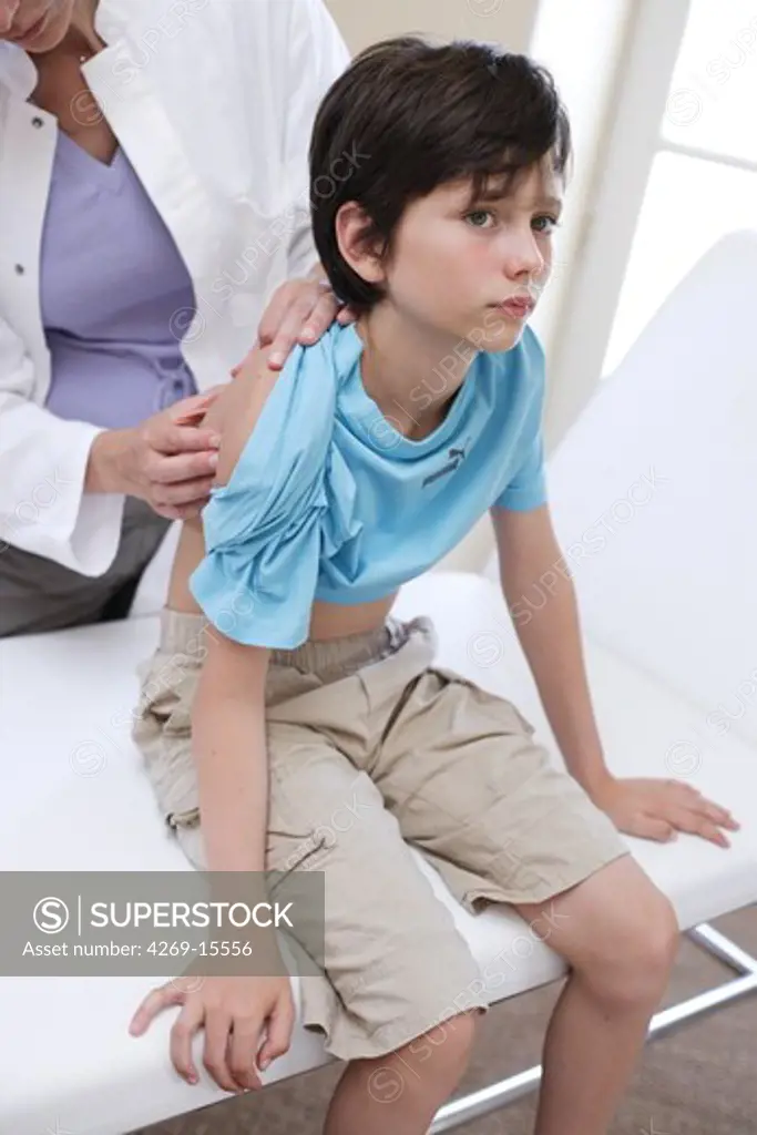 Doctor examining the skin of 9 years old child.