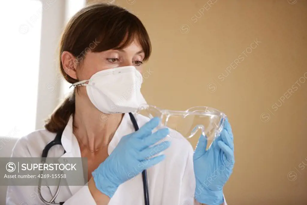 The French Health Minister recommends to health professionals to wear a protection in case of viral respiratory diseases (common cold, influenza). The doctor wearing mask, gloves and glasses.