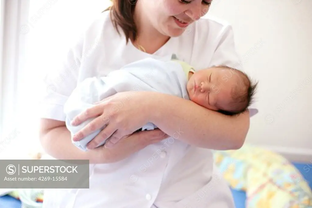 A paediatric auxiliary nurse runs a workshop to show parents how to carry their newborn baby. Obstetrics and gynaecology department, Saintonges hospital, Saintes, France.