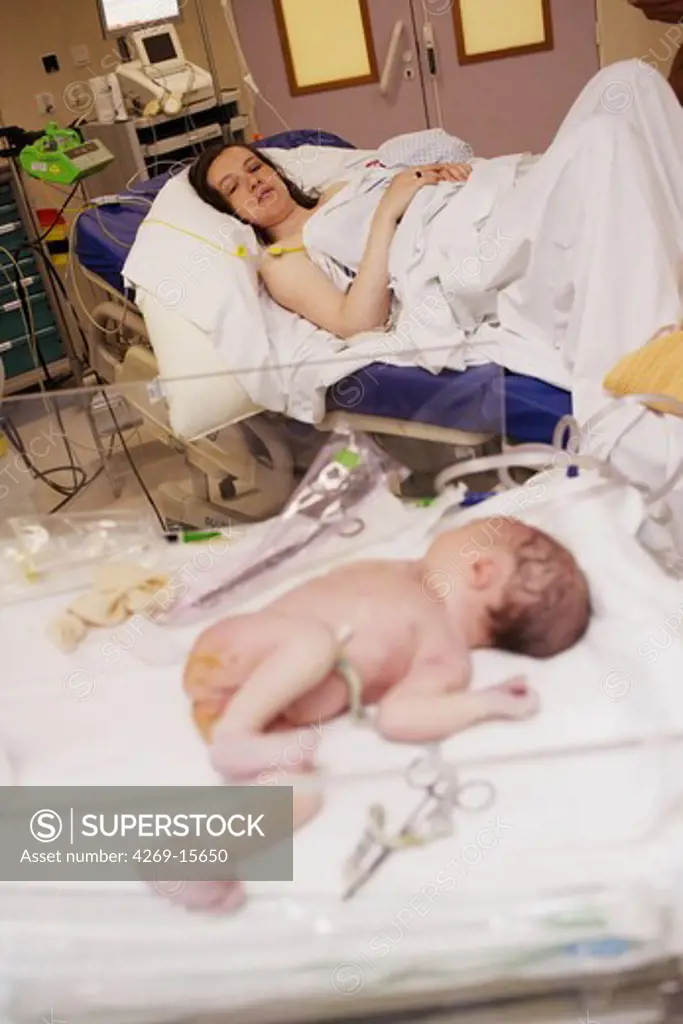Newborn baby with her mother in labor room just after delivery. Obstetrics and gynaecology department, Saintonges hospital, Saintes, France.