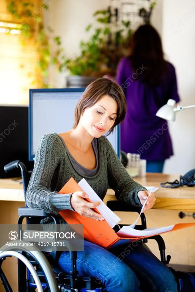 Woman in wheelchair working.