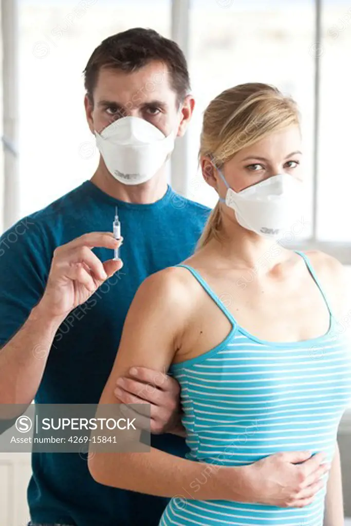 Woman receiving vaccination. General practitioner and patient wearing a respiratory protection mask during consultation with contagion hazard.