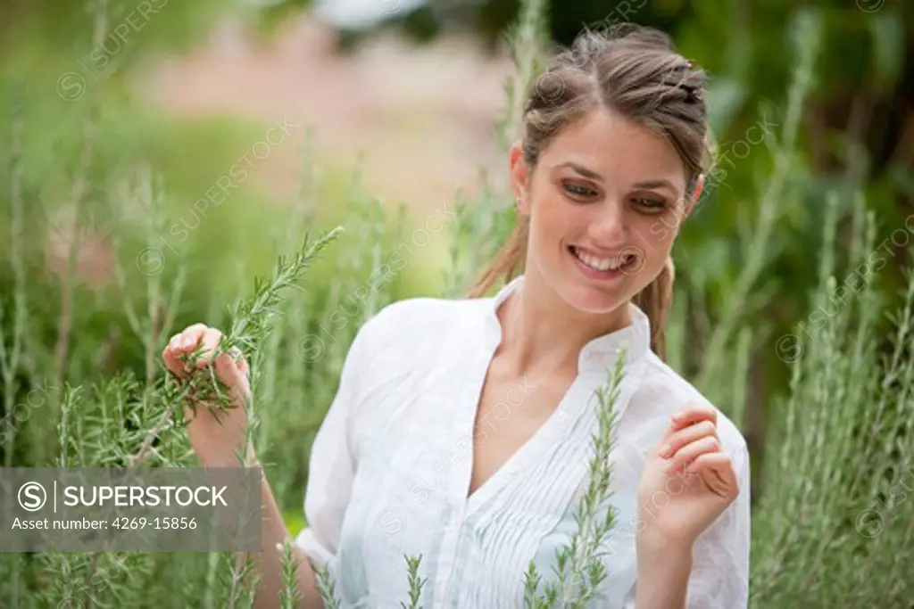Woman picking rosemary from the garden.