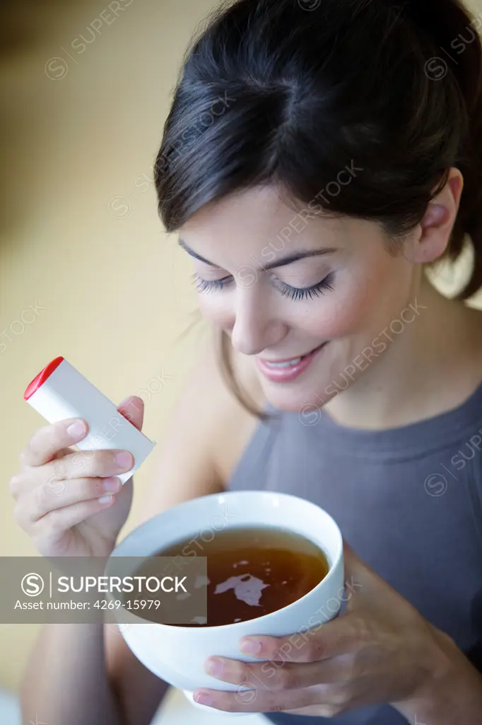 Woman using artificial sugar.