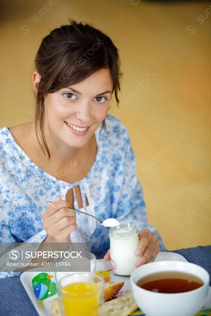 Woman adding sugar in yogurt.