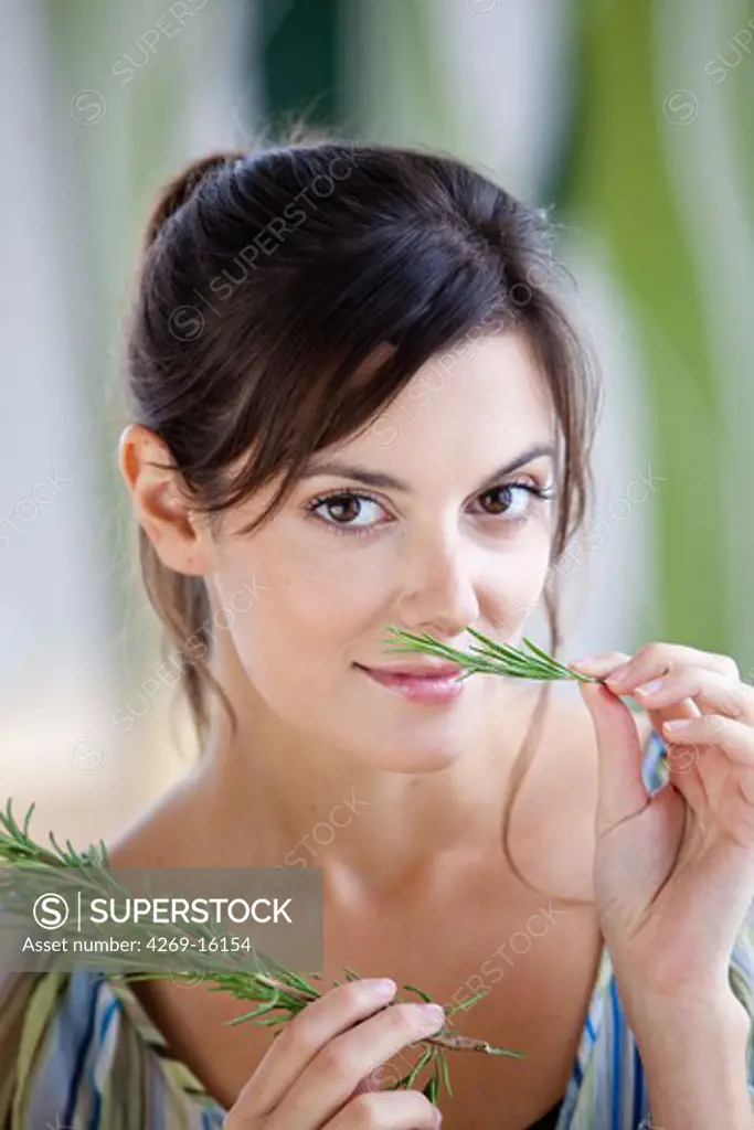 Woman smelling rosemary.