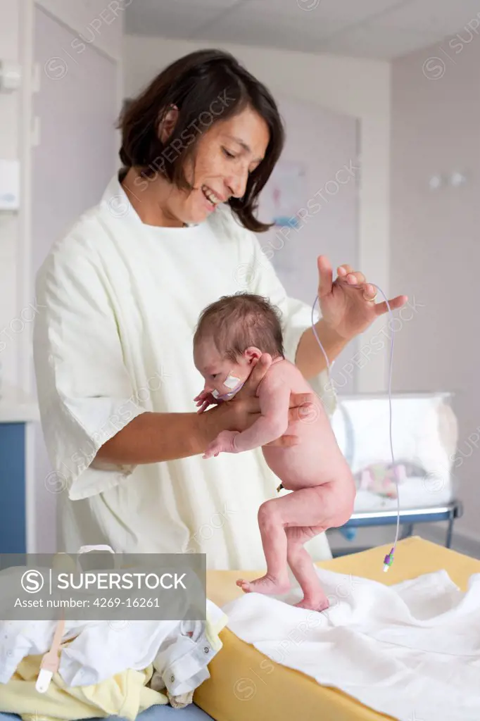 Pediatrician examining a premature newborn baby (stepping or walking reflex). Obstetrics and gynaecology department, Saintonges hospital, Saintes, France.