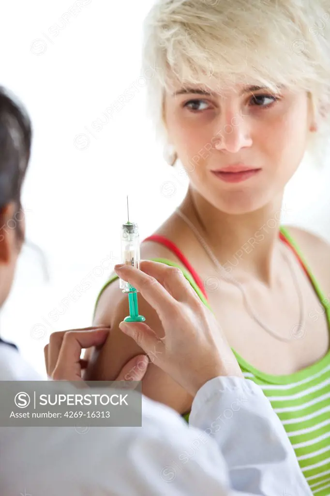 Teenage girl receiving vaccination (Gardasil vaccine) against certain types of the human papillomavirus (HPV) responsible for cervical cancer.