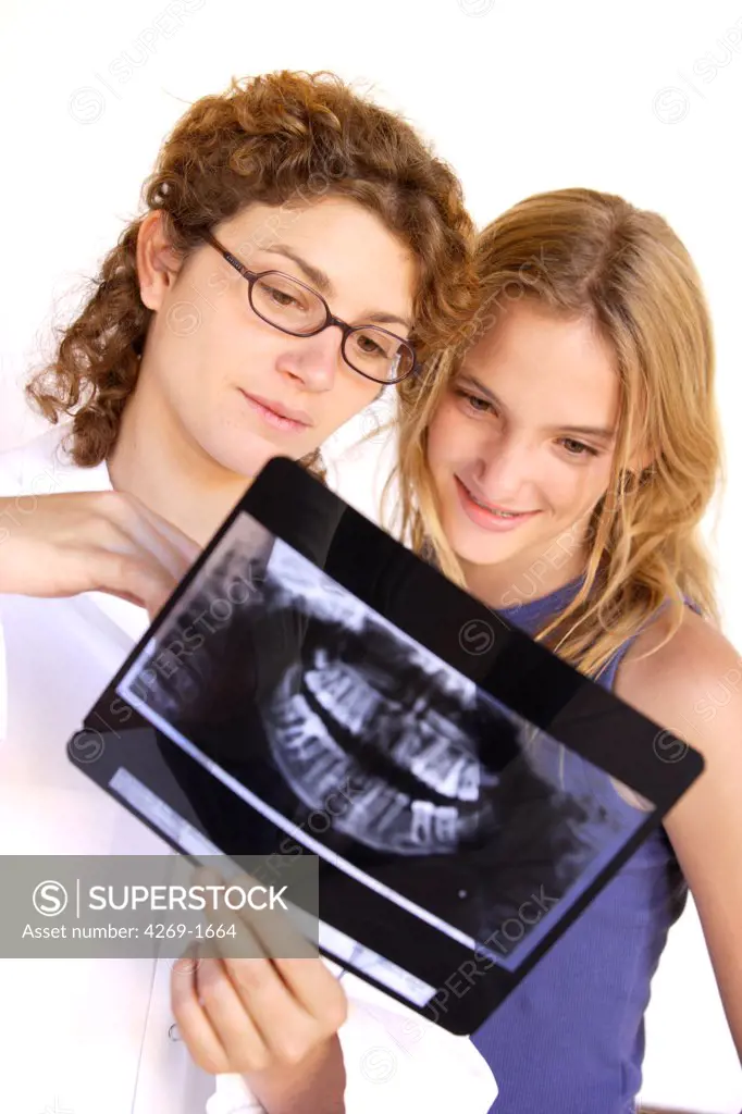 Orthodontist examining a 13 years old teenager's panoramic X-ray.