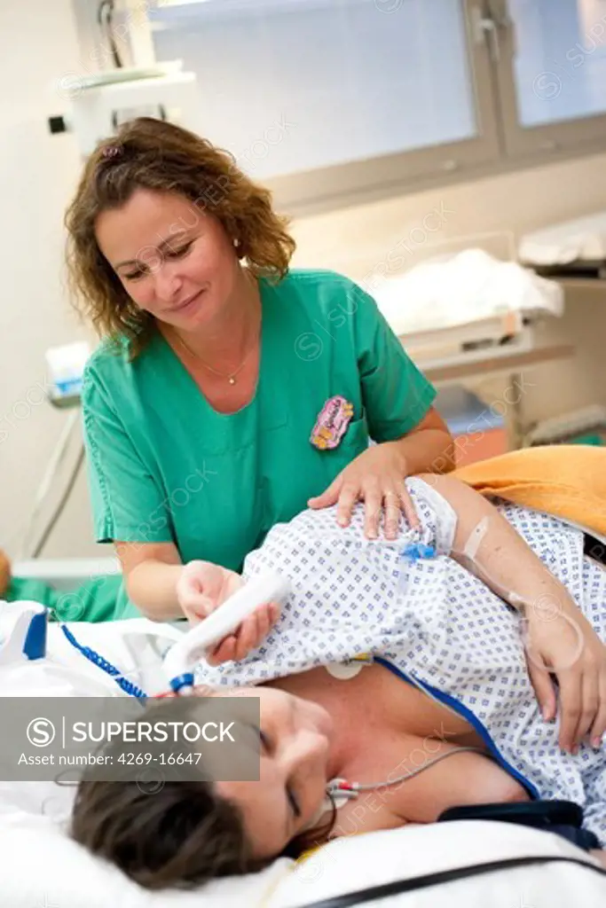 Midwife and pregnant woman before delivery. Obstetrics and gynaecology department, Saintonges hospital, Saintes, France.
