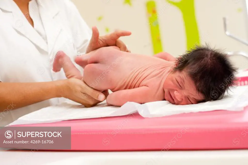 Pediatrician examining a newborn baby. Obstetrics and gynaecology department, Saintonges hospital, Saintes, France.