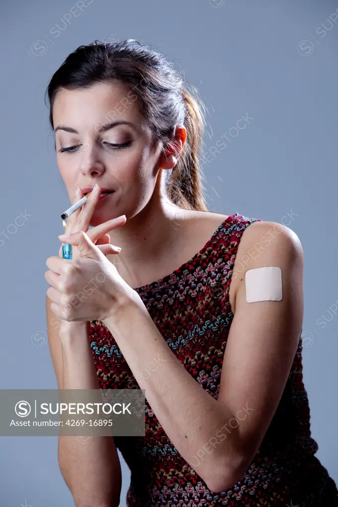 Woman with a tobacco control patch and smoking.