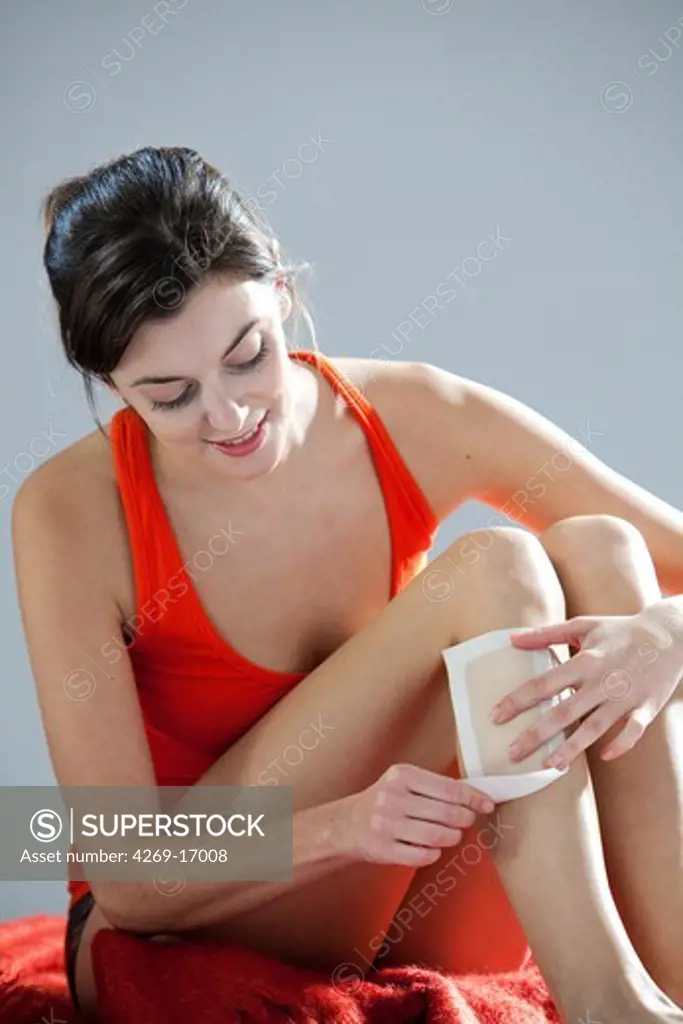 Woman wax epilation her legs.