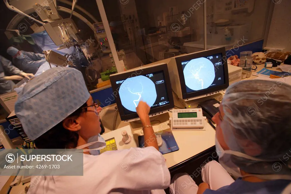 Unit of Laënnec Hospital of Nantes, France, specialized in Cerebrovascular Accidents (CVA). Technicians monitoring the interventional cerebral angiography (arteriography) on control screens while the patient is beeing operated. Use restriction : photo to be used in relation to neurovascular unit activities only.