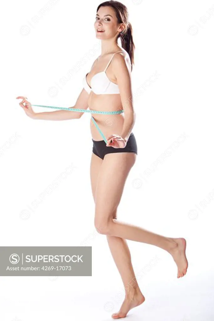 Woman measuring her waist.