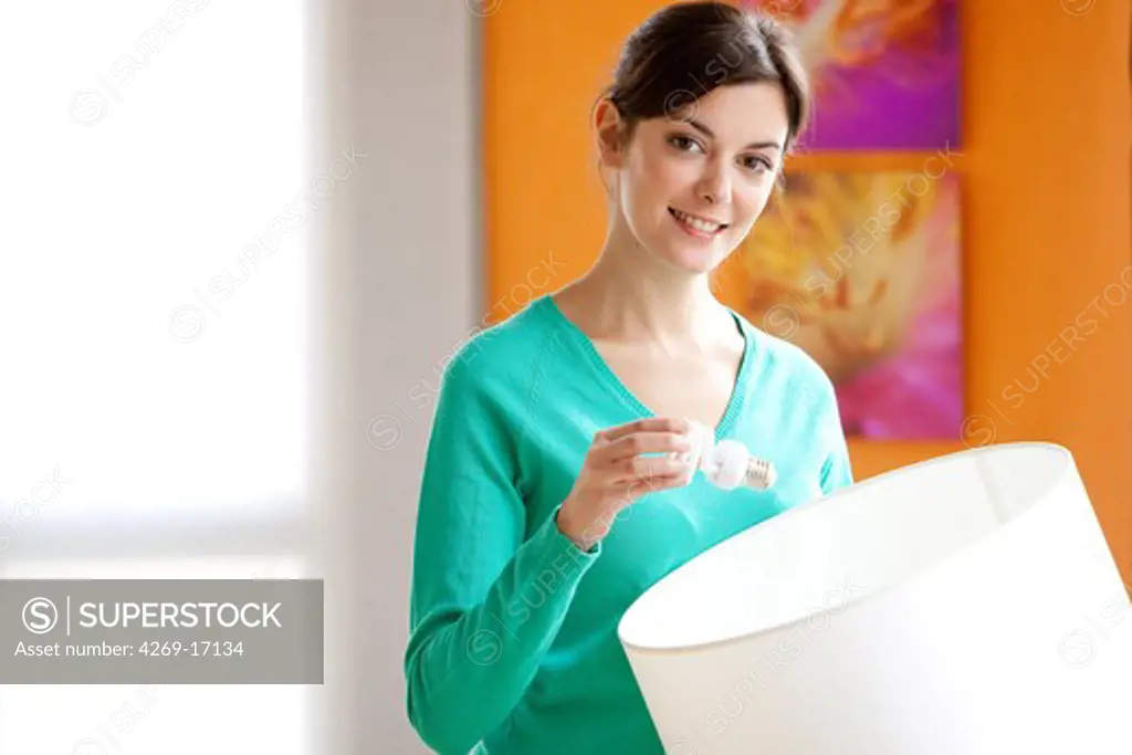 Woman putting an energy saving lightbulb.