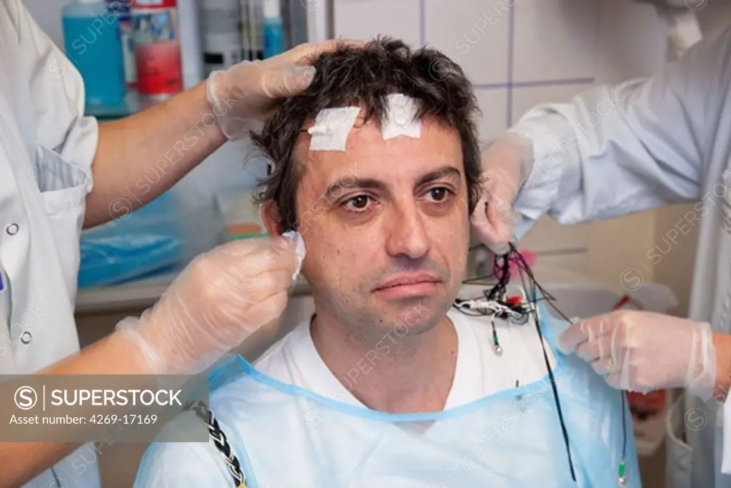 Man undergoing a polysomnographic examination. The polysomnography is the study of the physiological activity of the body during sleep, and includes the measurement of the lungs, heart and brain activity. The interpretation of these recordings can reveal disfunctions like sleep apnea, snoring, hypersomnia, insomnia...