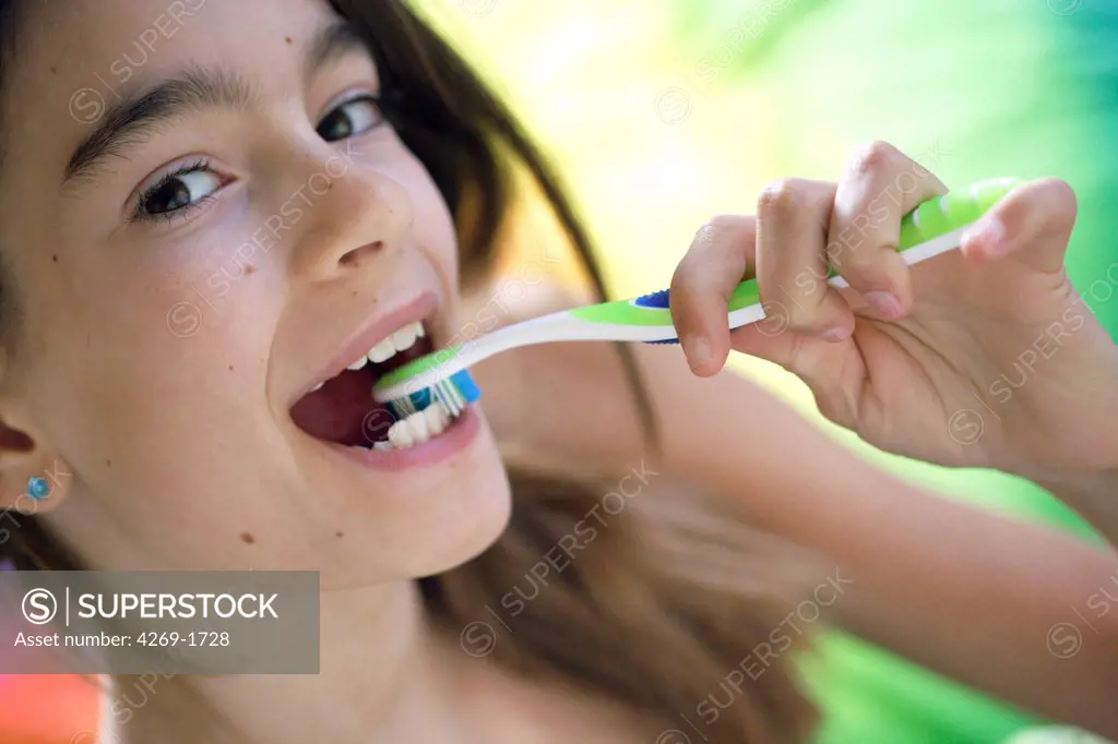 11 years old girl brushing her teeth.