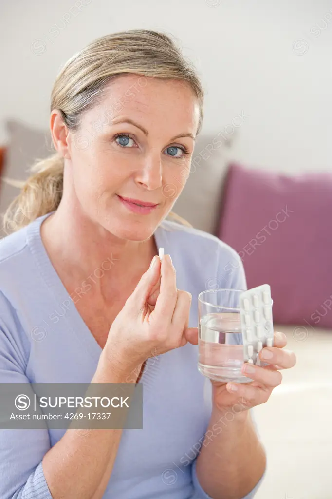 Woman taking medicine.