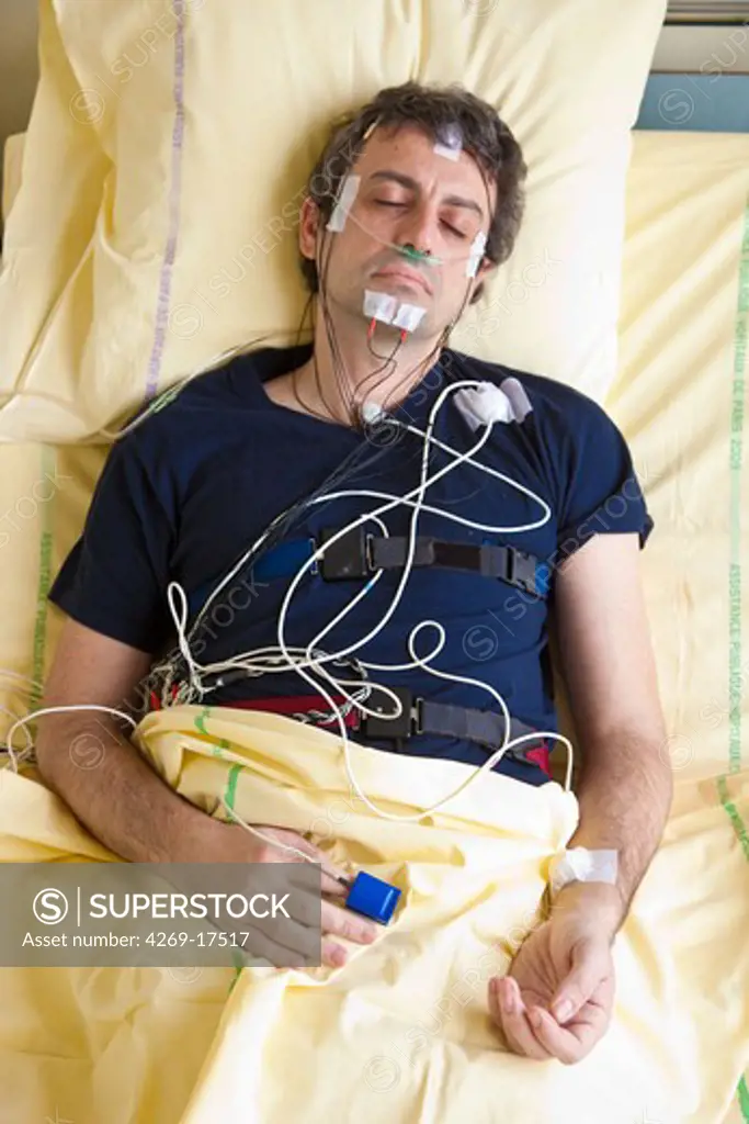 Man undergoing a polysomnographic examination. The polysomnography is the study of the physiological activity of the body during sleep, and includes the measurement of the lungs, heart and brain activity. The interpretation of these recordings can reveal disfunctions like sleep apnea, snoring, hypersomnia, insomnia...