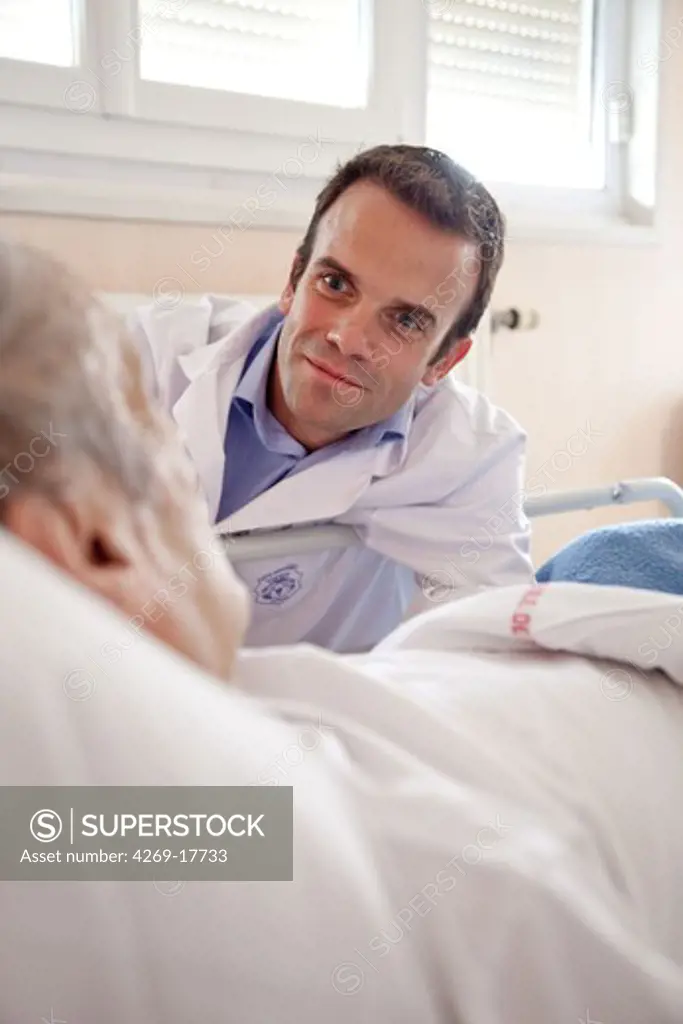 Doctor at patient's bedside. Palliative care department, hospital of Puteaux, France.