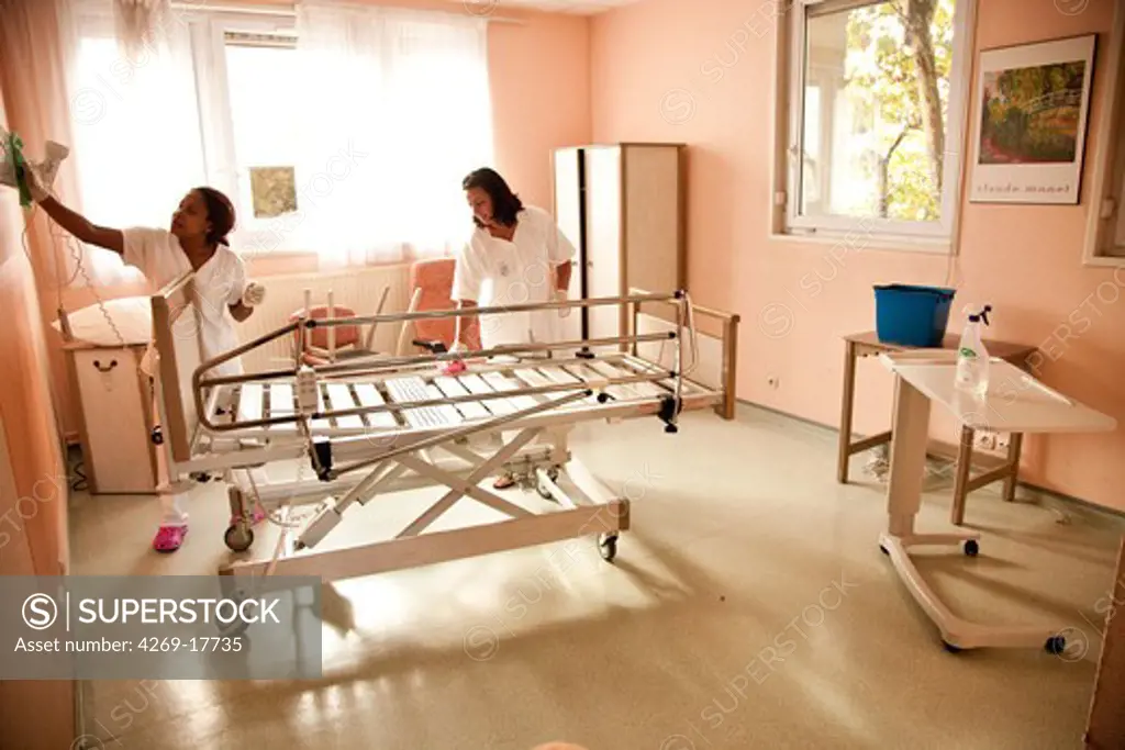 Staff cleaning a room after the death of a patient. Palliative care department, hospital of Puteaux, France.