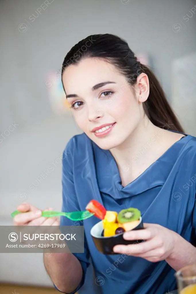 Woman eating a fruit salad.