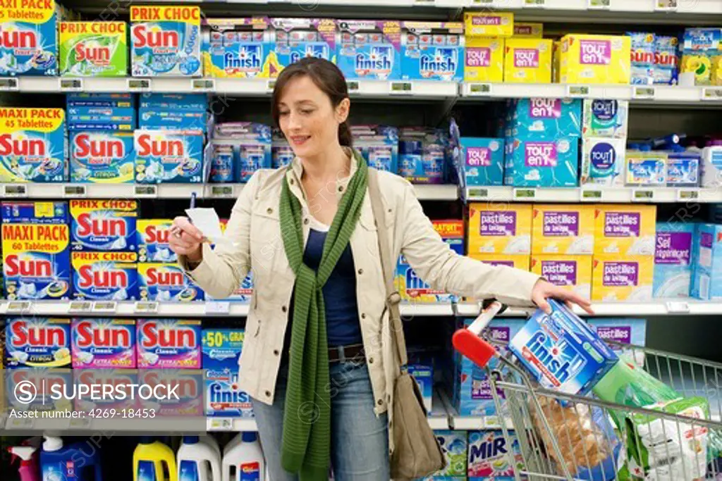 Woman shopping in cleaning products section in supermarket.