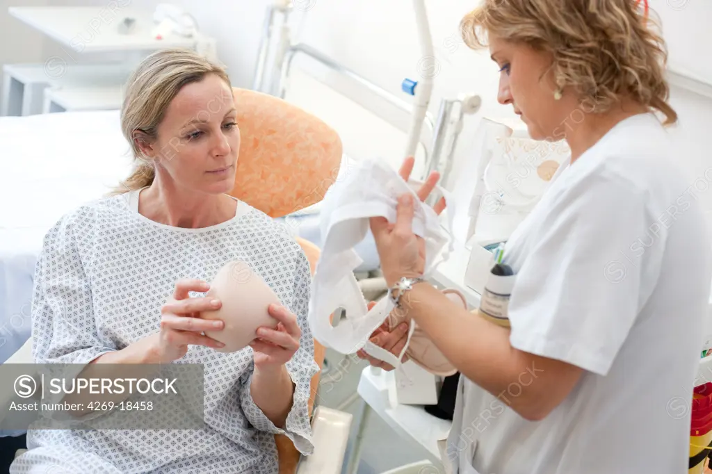 Nurse showing a woman have had a mastectomy different external breast prostheses and post-operative bra. Department of Gynecology, Limoges hospital, France.