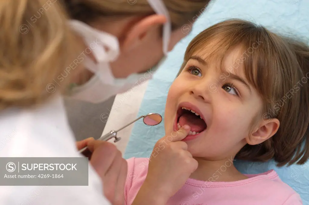 Dentist examining the teeth of a 4 years old child.