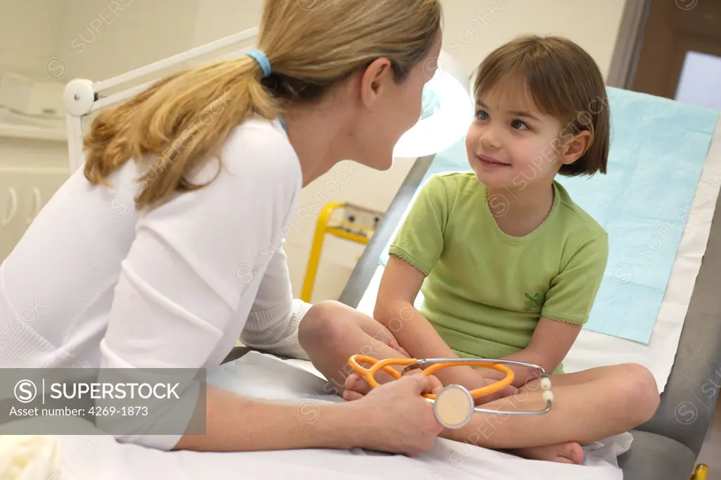 Doctor talking with a 4 years old little girl during medical consultation.