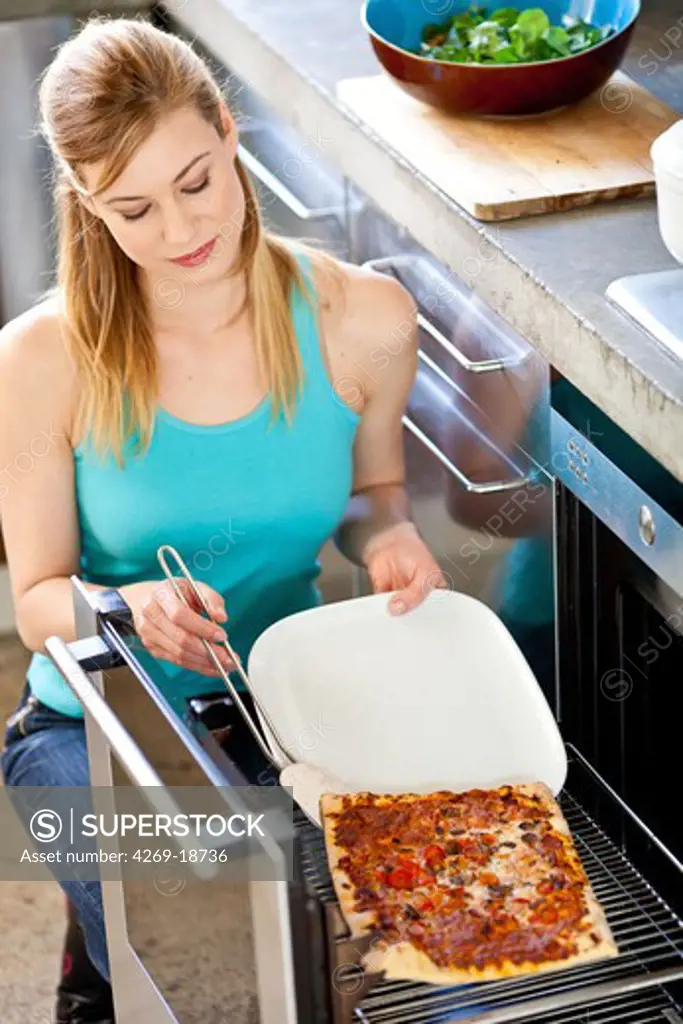 Woman preparing a pizza.