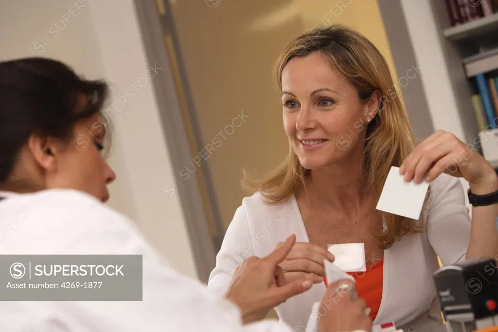 A doctor explains a 40 years old female patient the use of the oestrogen patch used in a Hormone Replacement Therapy.