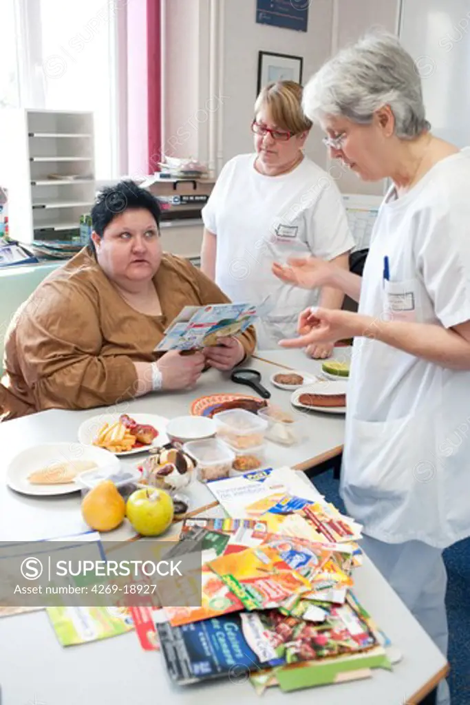 A nurse is holding a nutritional education workshop for obese patients. Limoges hospital offers its obese patients requiring hospitalization for five days for a multidisciplinary management of obesity. Department of Internal Medicine, Endocrinology, Diabetes and Metabolic Diseases. Limoges, France.