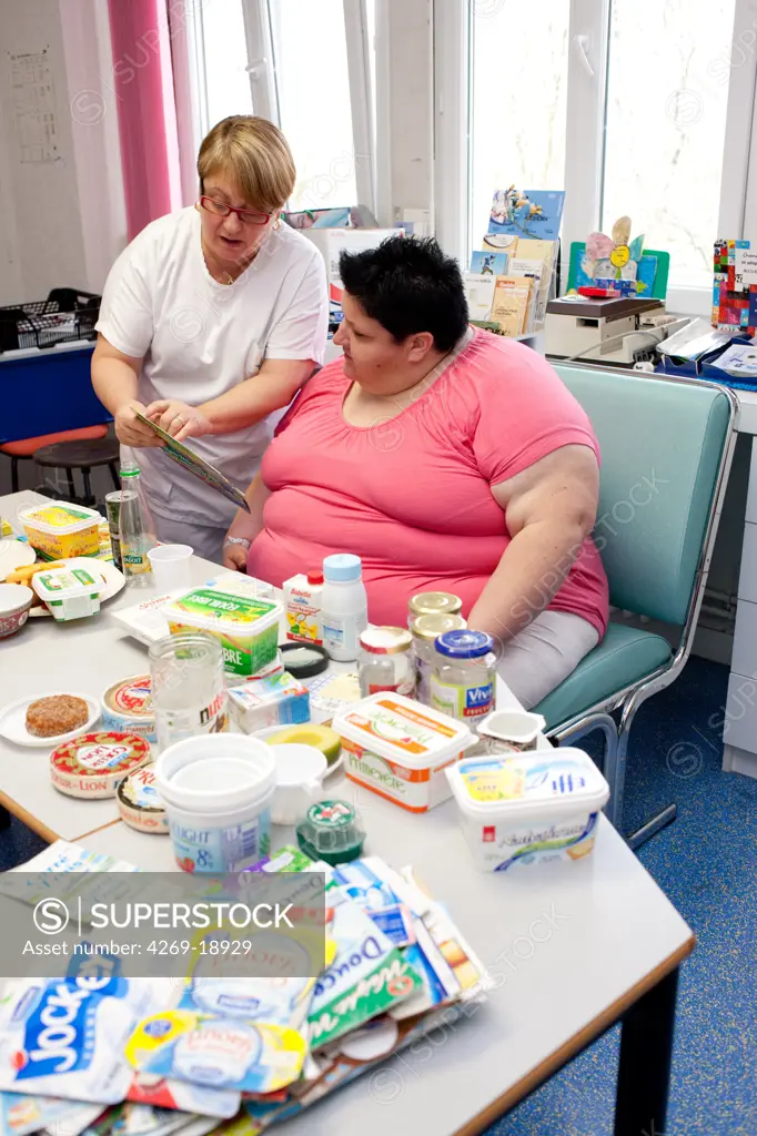 A nurse is holding a nutritional education workshop for obese patients. Limoges hospital offers its obese patients requiring hospitalization for five days for a multidisciplinary management of obesity. Department of Internal Medicine, Endocrinology, Diabetes and Metabolic Diseases. Limoges, France.