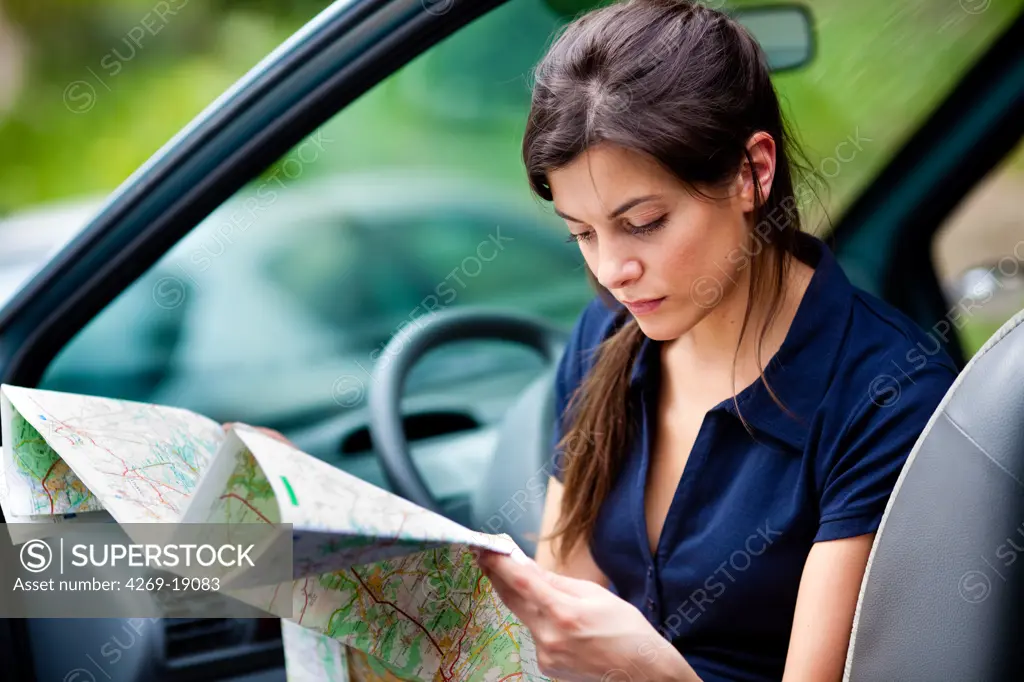 Woman driver reading a road map.