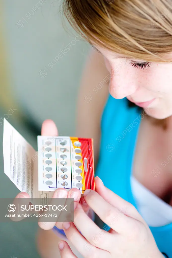 Teenage girl holding oral contraception pills.