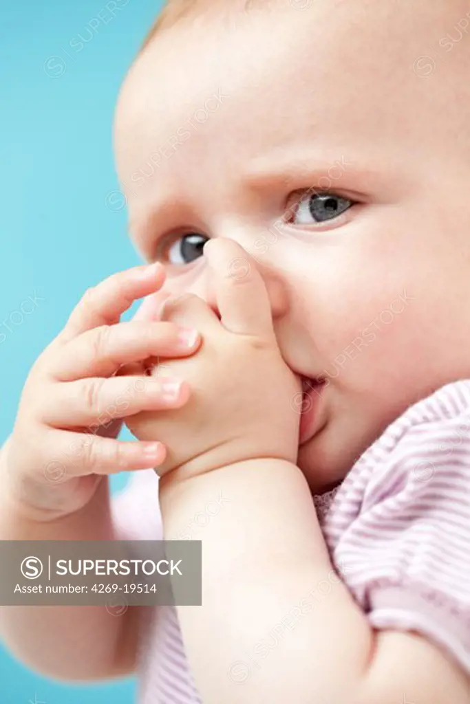 5 months old baby girl sucking her thumb.