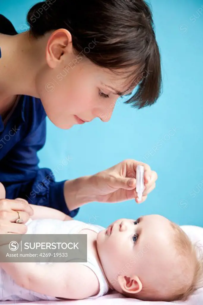 Mother putting eye-drops in her 5 months old baby's eyes.