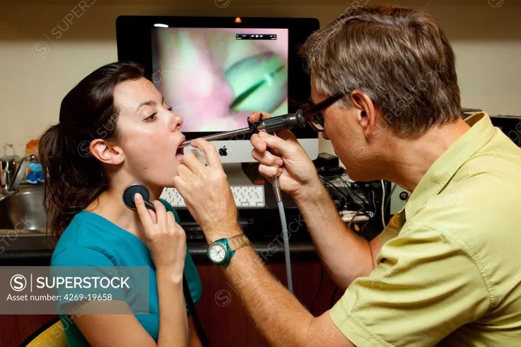 Female patient in consultation with a speech pathologist. Direct stroboscopic optic endoscopy of vocal cords. This examination can visualize the true color of mucous membranes. Rigid endoscope.