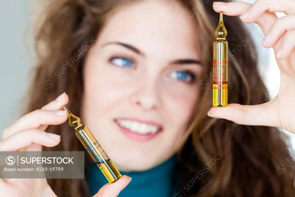 Woman holding glass ampoules of vitamin D.