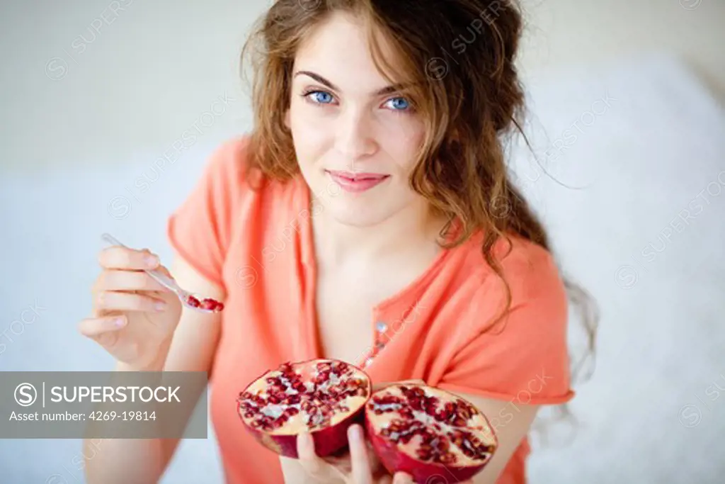 Woman eating pomegranate.
