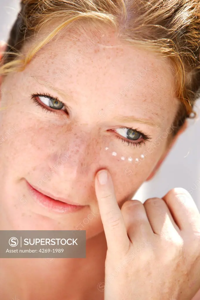 Woman applying anti-wrinkle cream around the eyes.