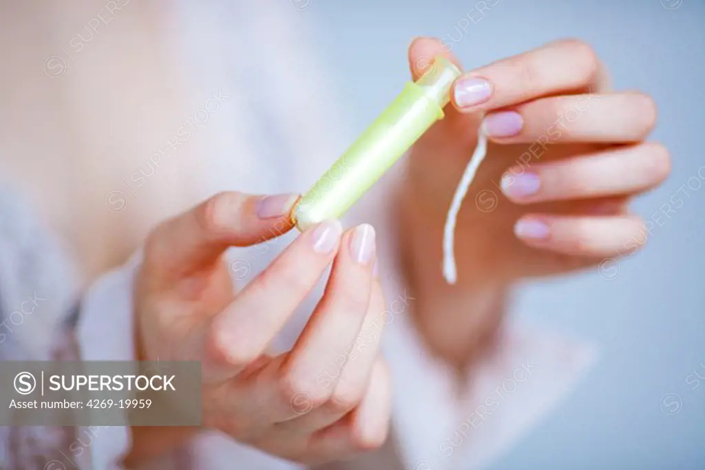 Woman holding a tampon.
