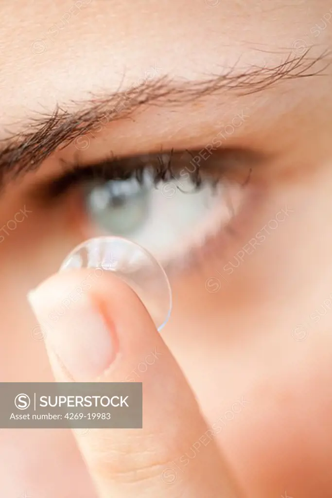 Woman putting on contact lens.