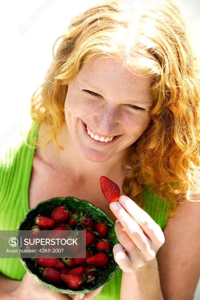 Woman eating strawberries.