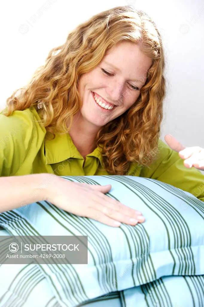 Woman cleaning pillows.